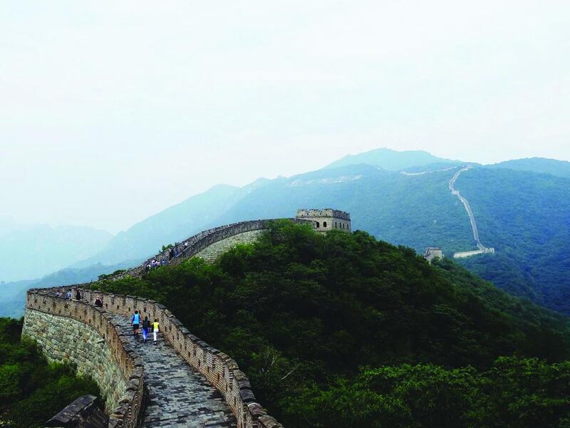 Tourists Walking On Great Wall Of China Against Sky. Getty Images