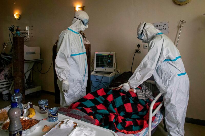 Doctors in personal protective equipment check health status of a patient who is infected with the coronavirus in the intensive care unit of Saint Petros Hospital in Addis Ababa, Ethiopia. AFP