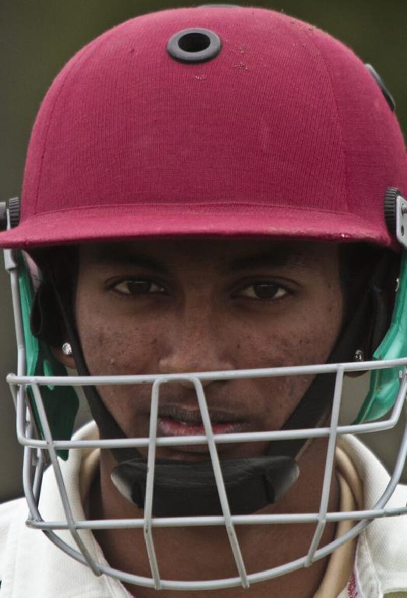 In this May 12, 2014 photo, Derick Narine, currently the top cricket player in New York City's Public School Athletic League from John Adams High School, wears a helmet as he prepares to bat in a match against Midwood High School at Marine Park in the Brooklyn borough of New York. Bebeto Matthews / AP