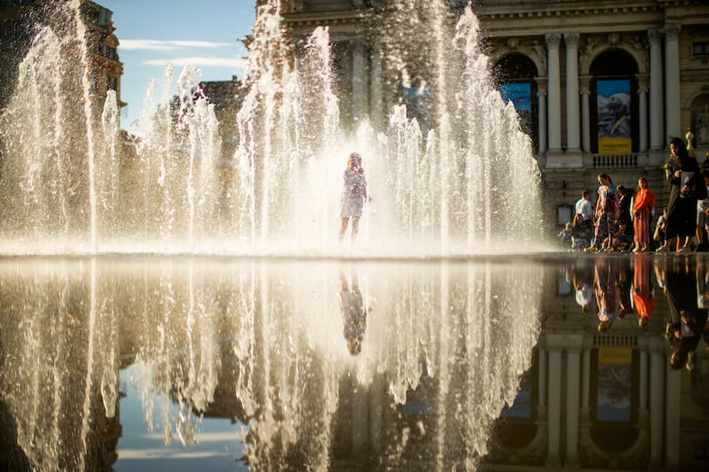 A girl runs through a fountain in front of the Opera house in Lviv, Ukraine. AP 