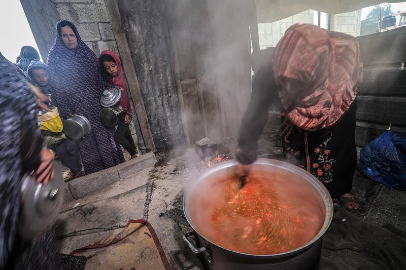 Amel Abu Amra stirs a cooking pot full of donated food. EPA