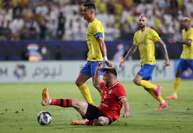 Al Nassr's Cristiano Ronaldo in action with FC Istiklol's Sodiqjon Qurbonov. Reuters