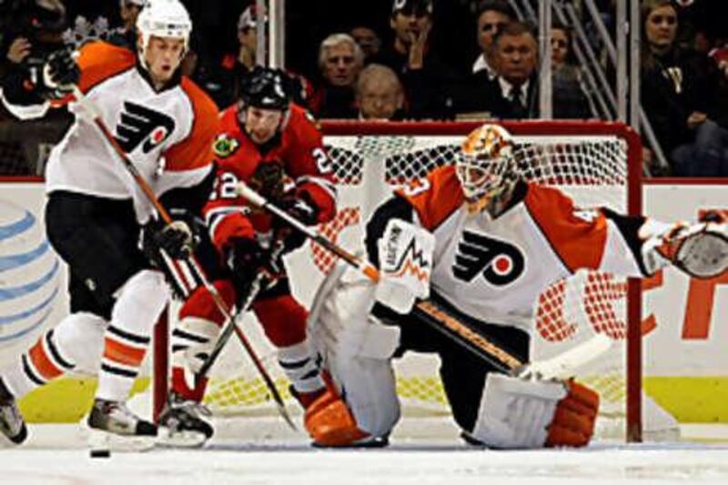 Chicago Blackhawks' Troy Brouwer, centre, battles for the puck with Philadelphia Flyers' Randy Jones, left, and the goalie Martin Biron during Chicago's 5-1 win