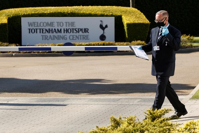 A man wearing a mask and gloves is seen at the car park entrance at Tottenham Hotspur training centre. Reuters