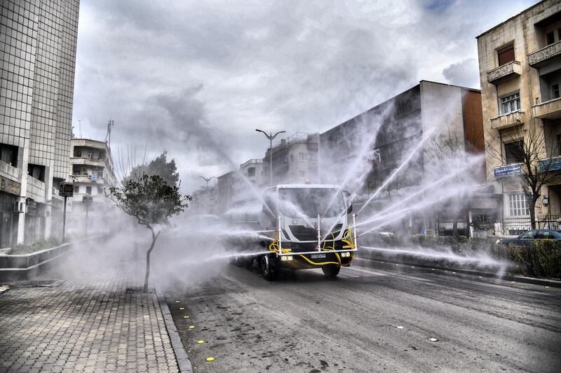 A handout picture released by the official Syrian Arab News Agency (SANA) on March 20, 2020 shows Syrian Red Crescent vehicles spraying disinfectant along a street in the capital Damascus, as part of measures against the spread of COVID-19 coronavirus disease. (Photo by - / SANA / AFP) / == RESTRICTED TO EDITORIAL USE - MANDATORY CREDIT "AFP PHOTO / HO / SANA" - NO MARKETING NO ADVERTISING CAMPAIGNS - DISTRIBUTED AS A SERVICE TO CLIENTS ==