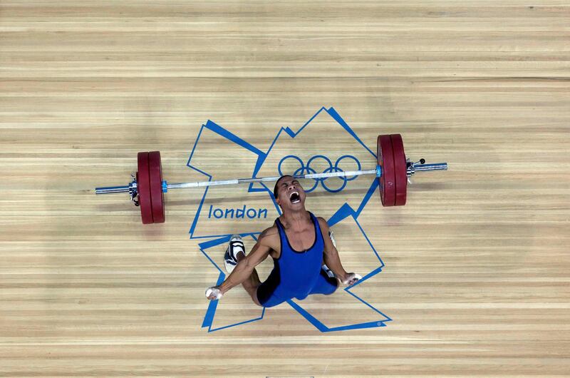 Micronesia's Manuel Minginfel drops weights on the men's 62Kg Group B weightlifting competition at the London 2012 Olympic Games July 30, 2012.        REUTERS/Dominic Ebenbichler (BRITAIN  - Tags: SPORT OLYMPICS SPORT WEIGHTLIFTING)   *** Local Caption ***  OLYJMR04_OLY-WEIG-W_0730_11.JPG