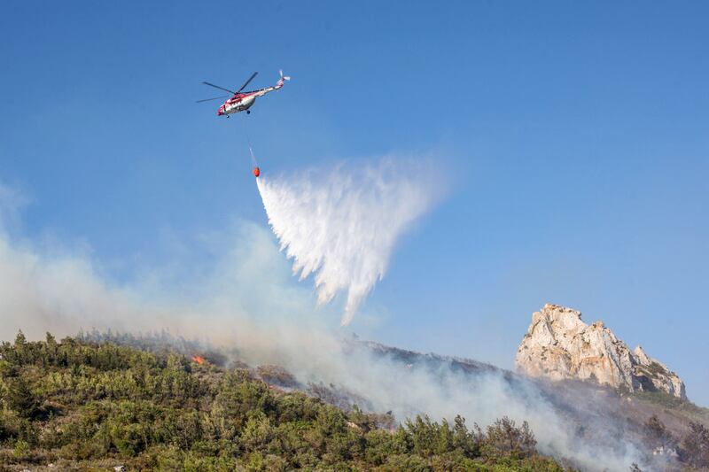 A helicopter douses flames as a forest fire rages in the Kyrenia mountains in the self-proclaimed Turkish Republic of Northern Cyprus, recognised only by Turkey, in June 2022. AFP