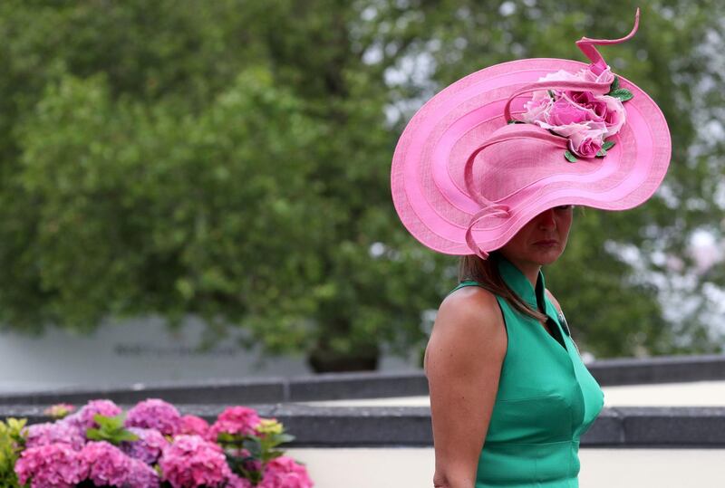 Contrasted against her green dress, this woman's shocking pink hat really stands out. AP