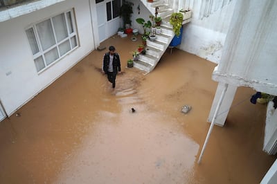 A man wades through a flooded courtyard following heavy rain in Dahuk. AFP
