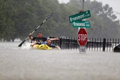 Two kayakers try to beat the current pushing them down an overflowing Brays Bayou along S. Braeswood in Houston, Texas, Sunday, Aug. 27, 2017. Rescuers answered hundreds of calls for help Sunday as floodwaters from the remnants of Hurricane Harvey climbed high enough to begin filling second-story homes, and authorities urged stranded families to seek refuge on their rooftops. (Mark Mulligan/Houston Chronicle via AP)