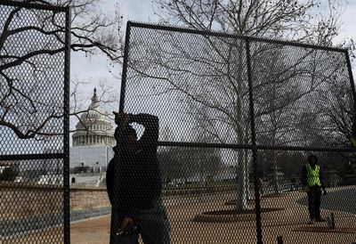 Workers install security fencing around the US Capitol before President Joe Biden's State of the Union address. Getty / AFP