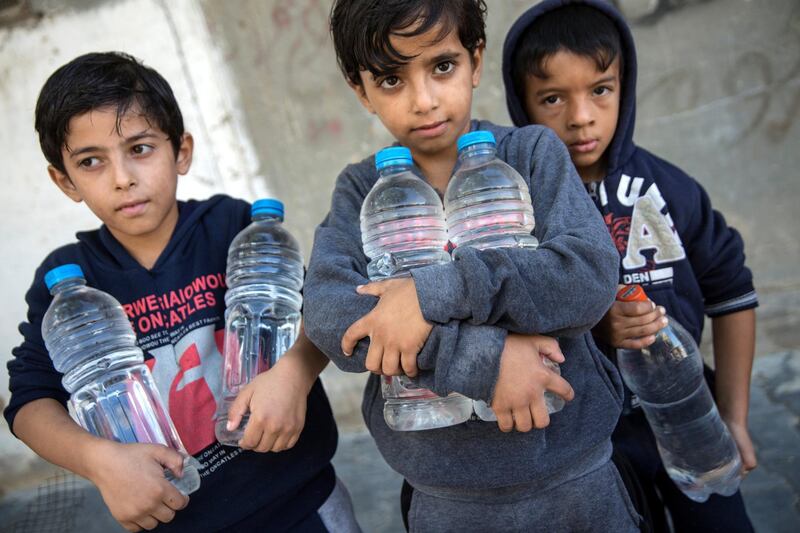 Palestinian boys hold bottles of water they collected from the tap at a mosque in El Bourej refugee camp in central Gaza on October 27,2018.Gaza's 2 million residents are facing a growing dire water crisis .(Photo by Heidi Levine for The National).