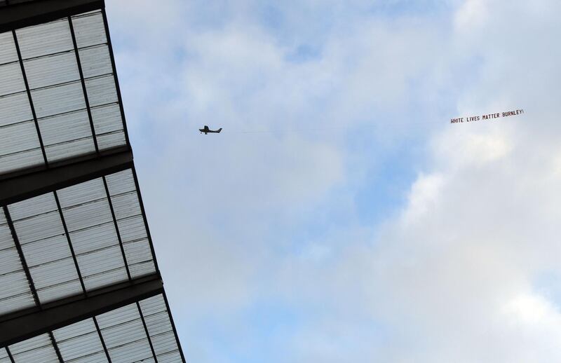 A plane towing a banner reading 'White Lives Matter Burnley' is seen in the sky above the stadium during the match between Manchester City and Burnley. AFP