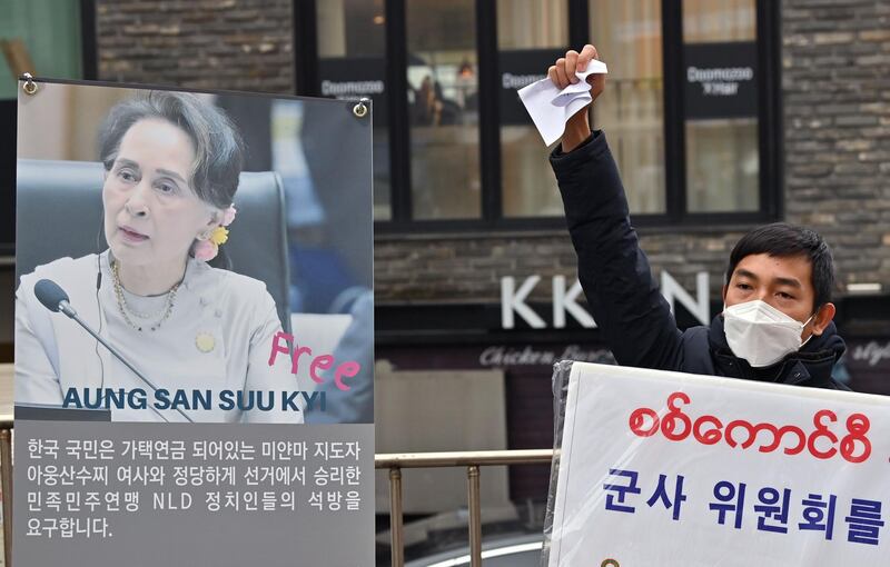 A Myanmar protester shouts slogans next to a banner showing a picture of Aung San Suu Kyi during a demonstration condemning the military coup in Myanmar, near the military office of the Myanmar embassy in Seoul.  AFP