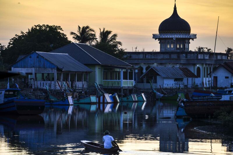 A man paddles his wooden boat after fishing during sunset at Kajhu beach, in Aceh.   AFP