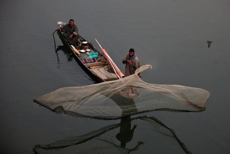 A fisherman casts his net in the waters of a flood channel on the outskirts of Srinagar. Danish Ismail / Reuters