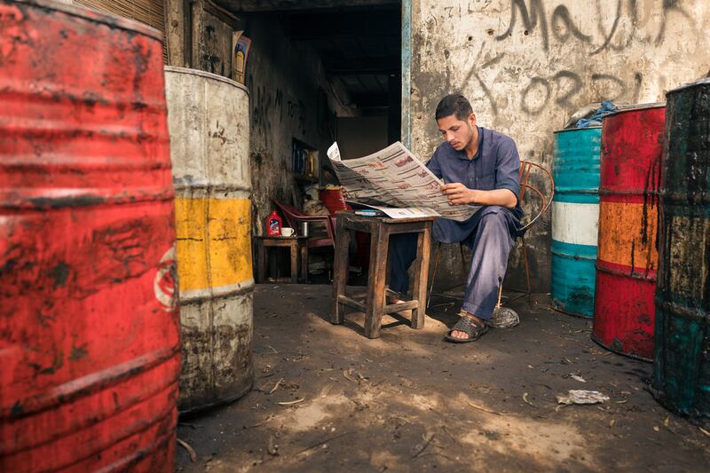A car mechanic reads a newspaper during a break in Sahiwal, Pakistan. Courtesy Sohail Karmani