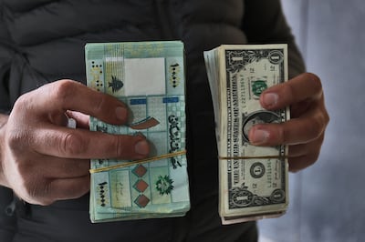 A black-market currency dealer holds US dollars and Lebanese pounds bills in Beirut on March 14. AFP