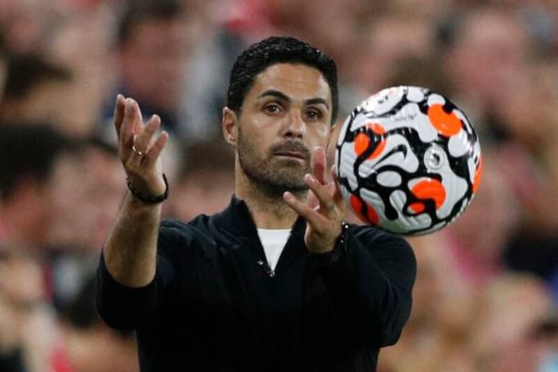 Arsenal's Spanish manager Mikel Arteta throws the ball to a playe.