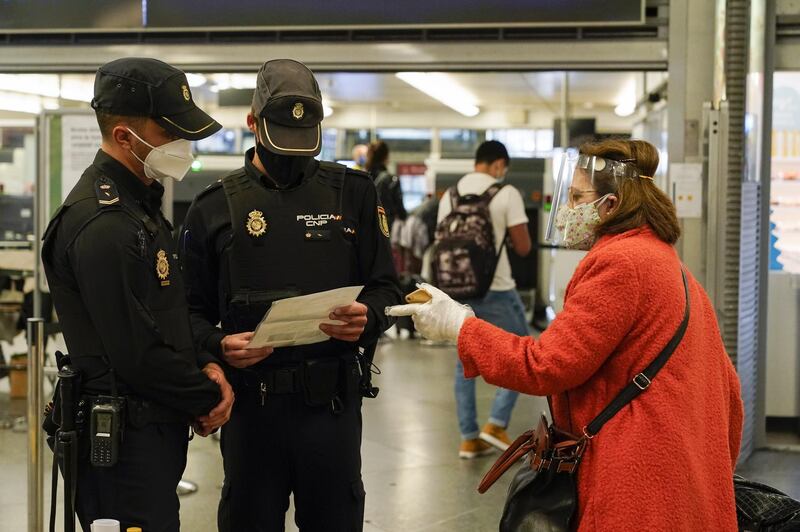Police officers check the documents of a passenger inside Atocha railway station in Madrid, Spain. Bloomberg