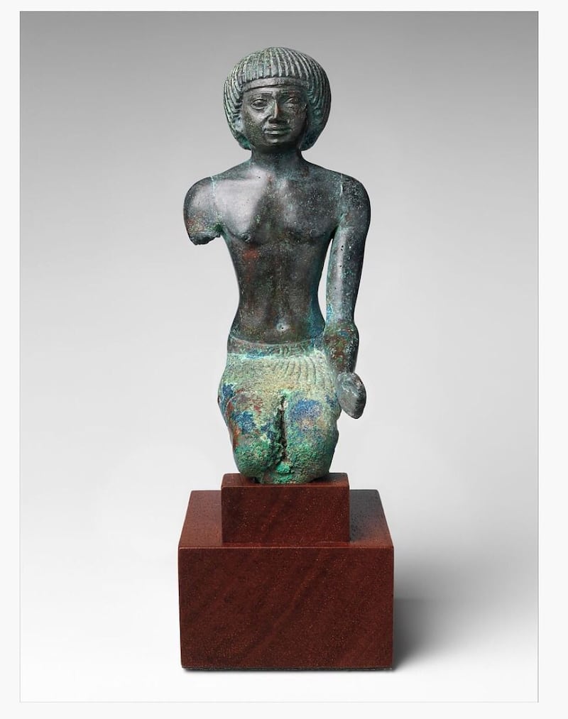 A bronze statue depicting a man kneeling. 