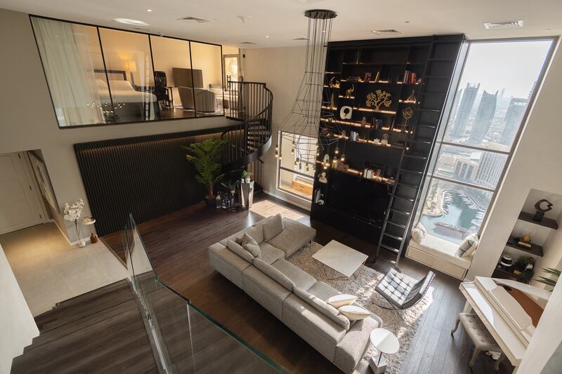 A view over the spacious double-height lounge and floor-to-ceiling bookshelf.