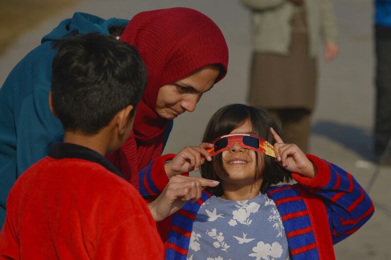 A child uses solar filter glasses to watch a solar eclipse in Islamabad.  AFP