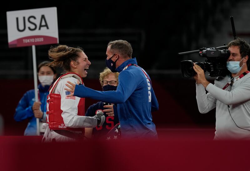 United States's Anastasija Zolotic, left, celebrates with coach after winning gold in taekwondo women's 57kg category.