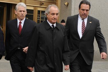 In this March 10, 2009 file photo, Bernard Madoff, centre, exits Manhattan federal court in New York. Mr Madoff is seeking an early release from prison. Photo: AP