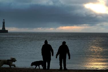 Men walk their dogs as the sun rises at Roker beach in Sunderland, England. Sunderland voted for Brexit to make itself heard, and in hope of a brighter future. AP Photo