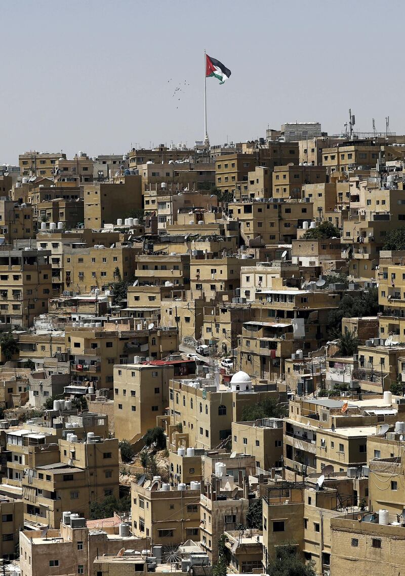 A general view taken from Jabal al-Qala district shows a Jordanian flag fluttering above the Jordanian capital Amman on June 8, 2018. 
Jordan's authorities may have shelved a proposed income tax hike after a week of protests -- but they still face the tricky task of balancing popular demands with the need to fix the economy. The controversial legislation sparked some of the biggest economic demonstrations to hit the country in the past five years, forcing a change of prime minister, with Hani Mulki stepping down in favour of Harvard-trained economist Omar al-Razzaz. 
 / AFP PHOTO / AHMAD GHARABLI