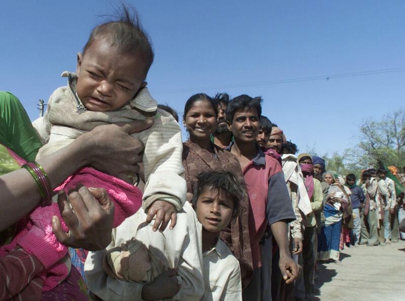 People queue for a food on the outskirts of the western Indian city of Bhuj on January 31, 2001. Relief supplies poured into the stricken state as the world's largest disaster relief network began a massive airlift of life-saving supplies. Hopes of finding more trapped survivors from India's earthquake dimmed on Wednesday and authorities turned their attention to caring for the homeless and preventing looting across the ravaged region.

PK/CC