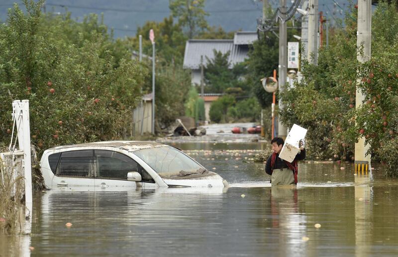 A man wades through floodwaters in Nagano. AFP