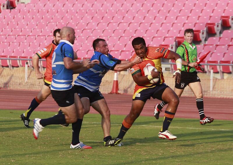 Mohammed Hassan, of the Arabian Knights in orange and black uniform, is tackled during the match against the Dubai Sharks yesterday. Jeffrey E Biteng / The National 

