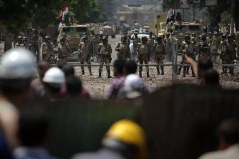 Egyptian soldiers stand guard around the Republican Guard building in Nasser City, Cairo.