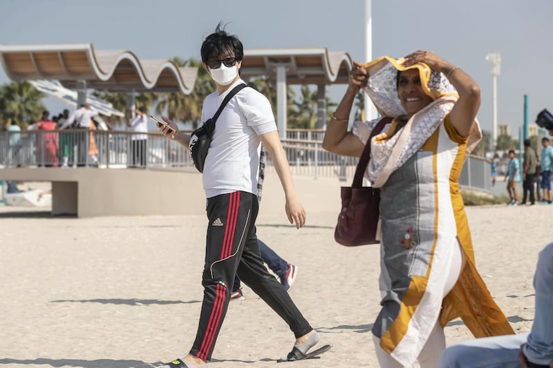 DUBAI, UNITED ARAB EMIRATES. 29 JANUARY 2020. Tourists and sightseers wear facial masks on Sunset Beach next to the Burj Al Arab and Jumeirah Beach Hotel.  (Photo: Antonie Robertson/The National) Journalist: Standalone. Section: National.

