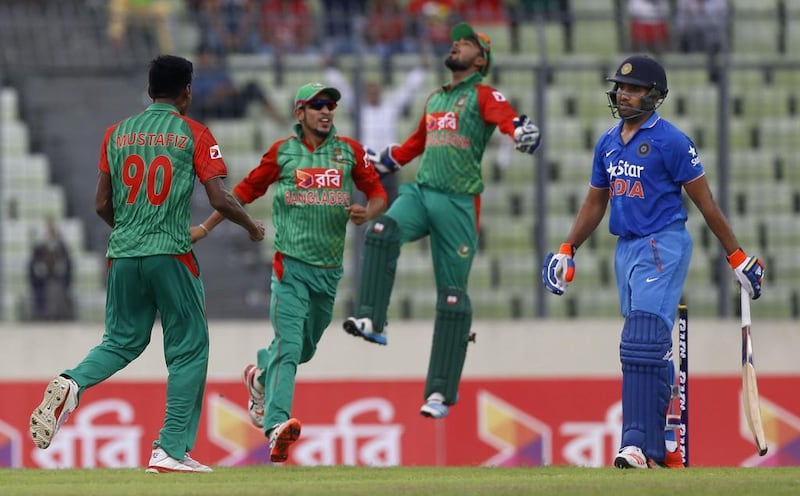 Bangladesh’s Mustafizur Rahman, left, celebrates with teammate Nasir Hossain, second left, and Litton Das, second right, after the dismissal of India’s Rohit Sharma, right, during their third one-day international cricket match in Dhaka, Bangladesh, Wednesday, June 24, 2015. (AP Photo/A.M. Ahad)