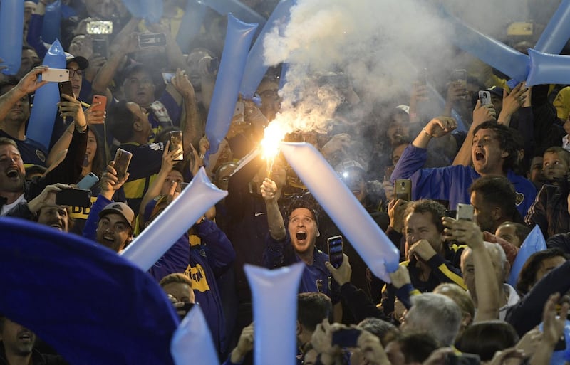 A fan of Boca Juniors holds a flare during the all-Argentine Copa Libertadores semi-final second leg football match against River Plate at La Bombonera stadium in Buenos Aires, on October 22, 2019. / AFP / Juan MABROMATA
