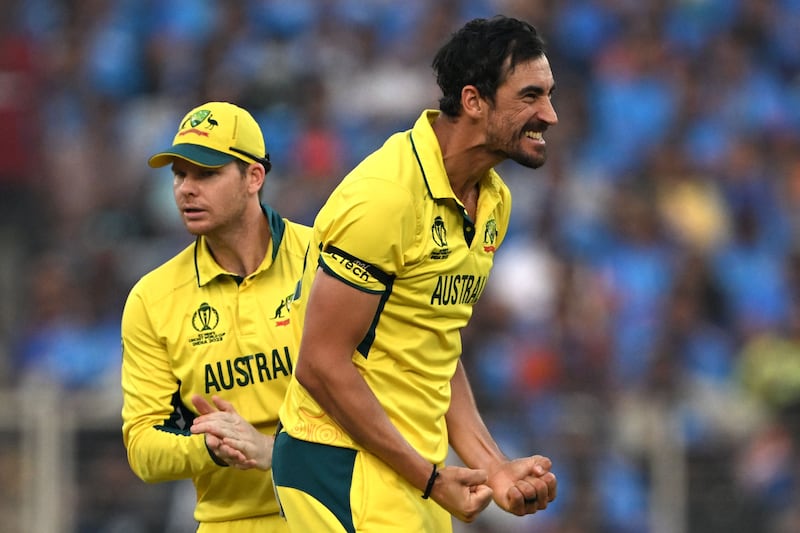 Australia's Mitchell Starc celebrates with teammate Steve Smith after taking the wicket of India's KL Rahul. AFP