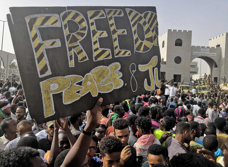 Sudanese anti-regime demonstrators, holding up a banner calling for "Freedom, Peace and Justice" carry on with their protest. AFP
