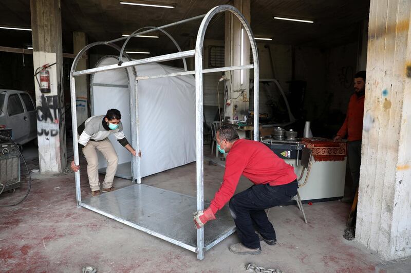 Palestinian employees build a disinfection chamber for local health centres, at a local garage in the West Bank city of Hebron, on April 2, 2020. EPA
