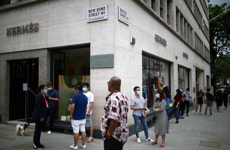 People are seen outside a Hermes store, as shops re-open amid the coronavirus disease outbreak, in New Bond Street in London, Britain June 15, 2020. REUTERS