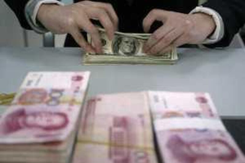 An employee counts U.S. dollar notes near renminbi notes at a bank in Nanjing, Jiangsu province, December 2, 2008. The yuan hit the bottom of its daily trading band against the dollar for a second straight day on Tuesday, amid speculation that China was shifting currency policy to allow moderate yuan depreciation as a way to stimulate its economy, traders said. REUTERS/Sean Yong (CHINA) *** Local Caption ***  PEK02A_MARKETS-CHIN_1202_11.JPG