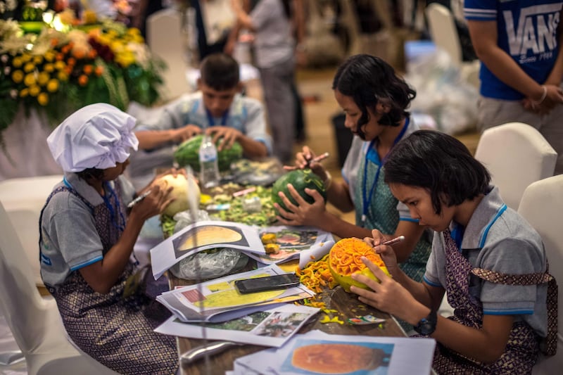 Thai children carve elaborate designs into fruit and vegetables during a fruit and vegetable carving competition in Bangkok. Robert Schmidt / AFP