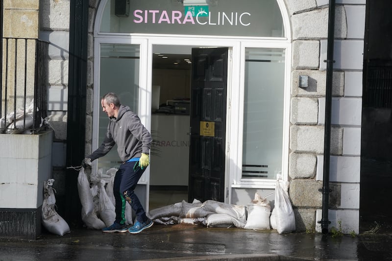 A man places sandbags outside a shop in Merchants Quay, Newry, Northern Ireland. PA