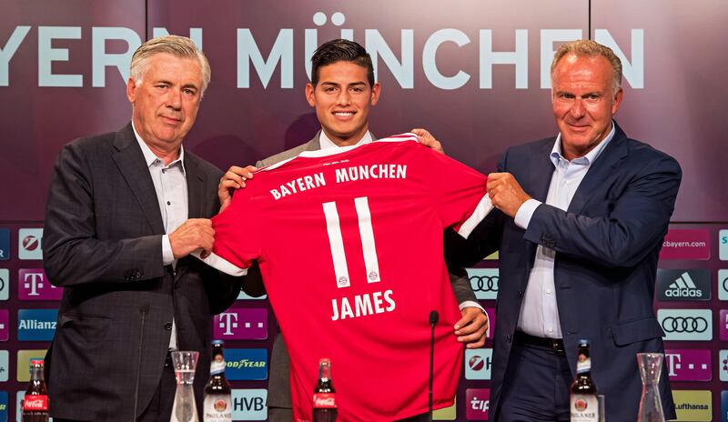 epa06083103 Bayern Munich's new player James Rodriguez (C) hold his new jersey with head coach Carlo Ancelotti (L) and CEO Heinz Rummenigge (R) as James is presented during a press conference in Munich, Germany, 12 July 2017. German Bundesliga soccer club Bayern Munich announced on 11 July 2017 James Rodriguez comes from Spain's Real Madrid on a two-year loan.  EPA/LUKAS BARTH