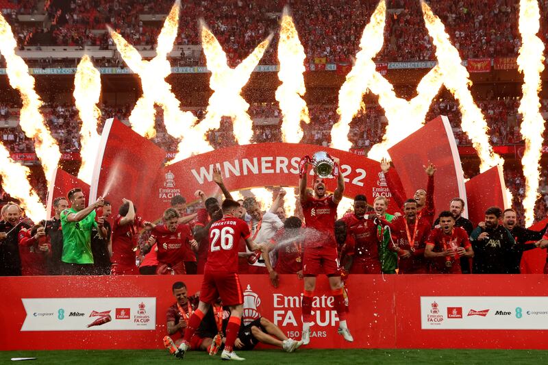 Liverpool's Jordan Henderson lifts the trophy. AP