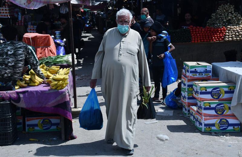 Iraqis wearing masks shop in the southern Iraqi city of Nssiriyah on March 25, 2020 amid the COVID-19 coronavirus pandemic.  / AFP / Asaad NIAZI
