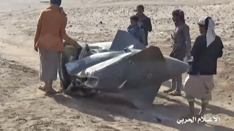 Yemenis gather around what appears to be part of the crashed Tornado fighter. AFP