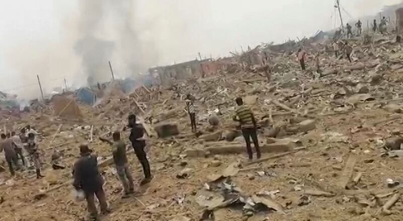 People gather where buildings once stood after a blast caused by a crash between a truck carrying explosives and a motorcycle occurred near the city of Bogoso, Ghana. All photos: AFP